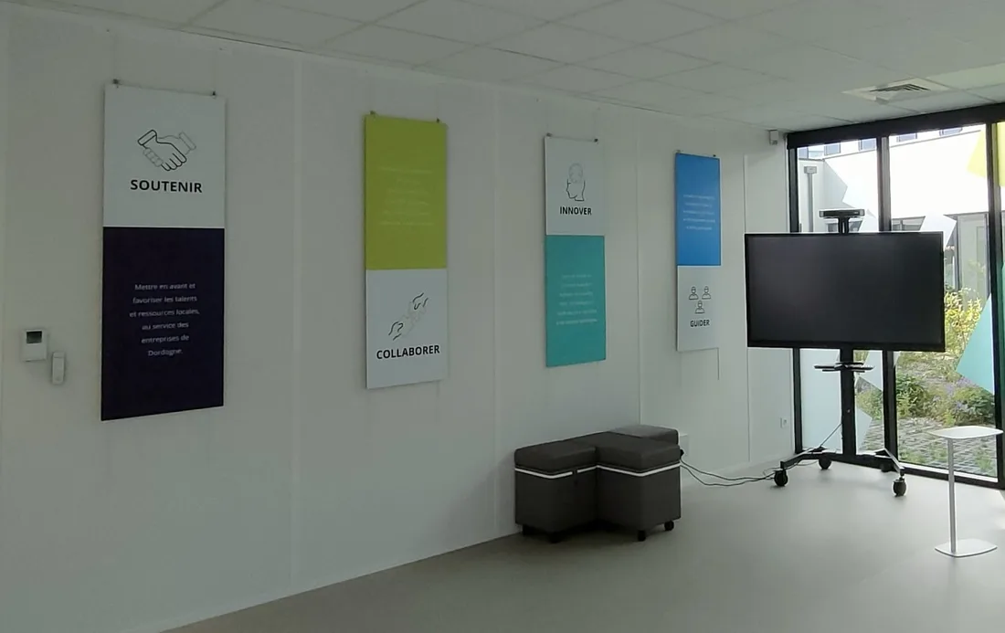 Mur des valeurs de Digital Valley (Soutenir, Collaborer, Innover, Guider) avec écran de réunion.